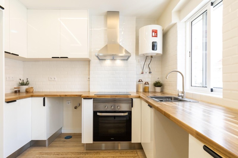 Wooden worktop, white units and metro tiling