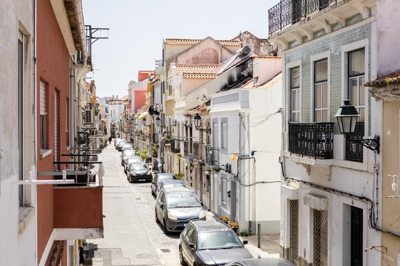 The street seen from the balcony, with old façades and iron lamps