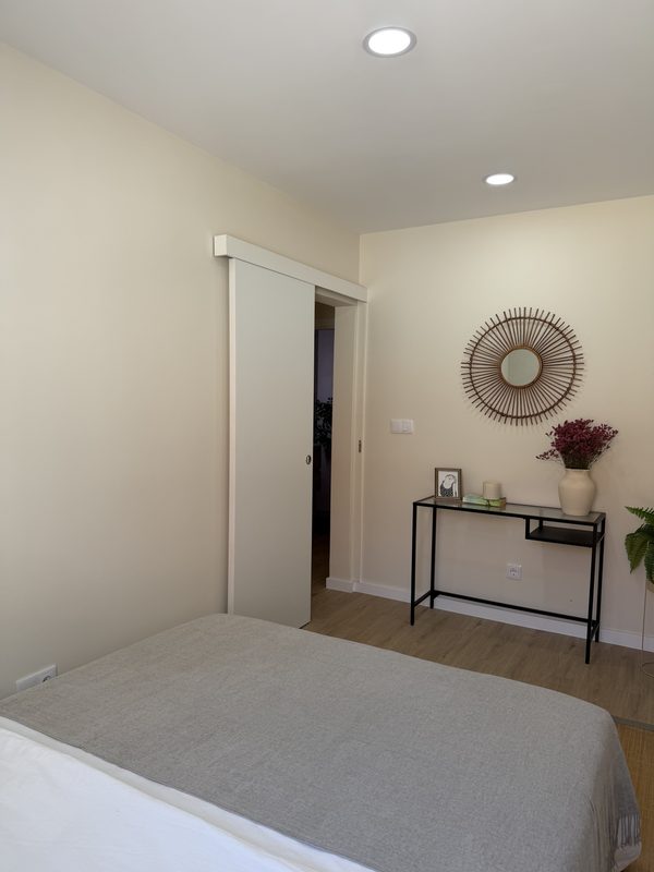 Quarto com porta de correr e consola junto à entrada